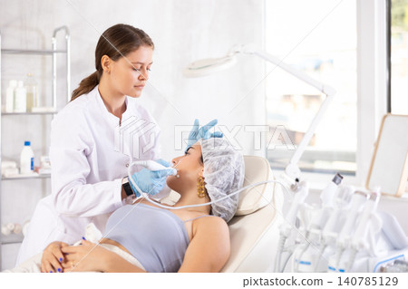 Aesthetician performing radiofrequency facial skin tightening procedure on young woman Aesthetician performing radiofrequency facial skin tightening procedure on young woman 140785129