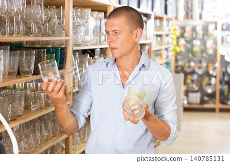 Man choosing glassware in store Man choosing glassware in store 140785131
