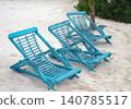 Three blue wooden beach chairs on tropical sand 140785517