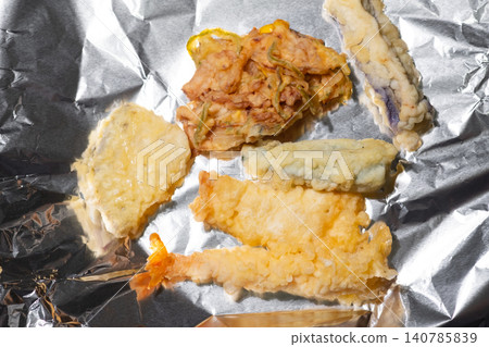 I'm about to heat up the store-bought tempura assortment by arranging it on aluminum foil. I'm about to heat up the store-bought tempura assortment by arranging it on aluminum foil. 140785839
