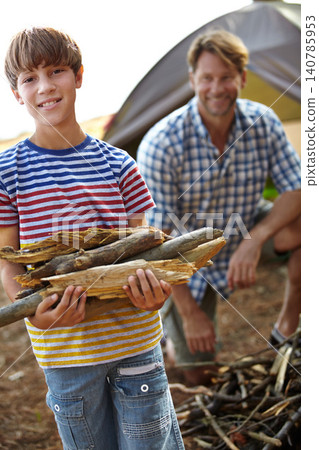 Boy, father and camping with wood in portrait for heat, cooking and learning on outdoor adventure. Child, papa and collecting firewood in forest, vacation and happy in nature by tent in Colorado 140785953