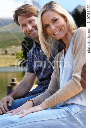 Smile, relax and portrait of couple by lake in summer for vacation, holiday and bonding at countryside. Man, woman and happy for outdoor weekend adventure, travel and tourism with love in Europe Smile, relax and portrait of couple by lake in summer for vacation, holiday and bonding at countryside. Man, woman and happy for outdoor weekend adventure, travel and tourism with love in Europe 140785961