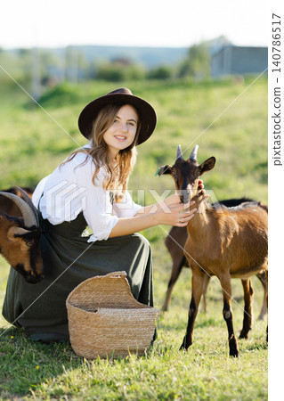 Farmer woman petting a goat in a field Farmer woman petting a goat in a field 140786517