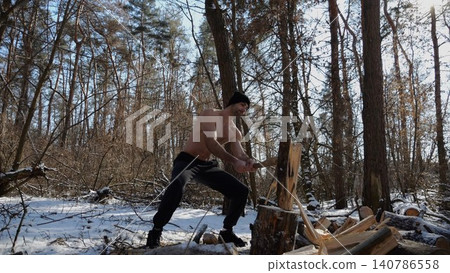 Shirtless strong man chopping firewood in a sunny winter forest. Muscular guy working with axe in snowy woodland. Concept of strength, masculine, energy and harmony with nature during cold season Shirtless strong man chopping firewood in a sunny winter forest. Muscular guy working with axe in snowy woodland. Concept of strength, masculine, energy and harmony with nature during cold season 140786558