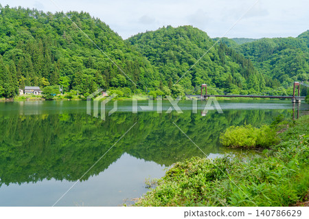 A bridge over a river surrounded by fresh greenery A bridge over a river surrounded by fresh greenery 140786629
