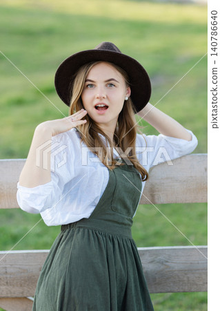 Surprised farmer looking amazed touching her face and adjusting her hat 140786640