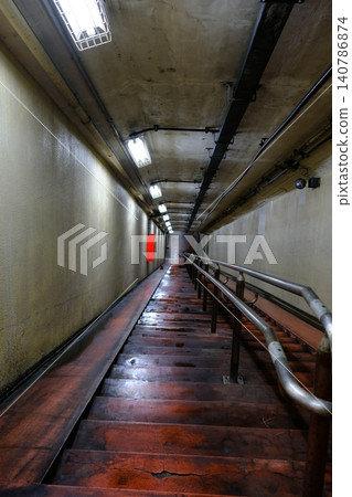 A sense of depth that leads to another world. A walkway in an underwater tunnel illuminated by lights. A sense of depth that leads to another world. A walkway in an underwater tunnel illuminated by lights. 140786874