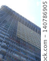 A construction site bathed in the early summer light, the intricate beauty of the scaffolding reaching towards the sky. 140786905