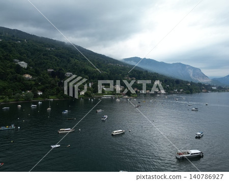 Cloudy sky hovers over calm, green-lit lake Cloudy sky hovers over calm, green-lit lake 140786927
