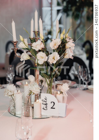 Soft pink tablecloth with elegant candle arrangement Soft pink tablecloth with elegant candle arrangement 140786937