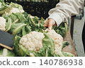 Fresh cauliflower heads rest on a wooden counter 140786938