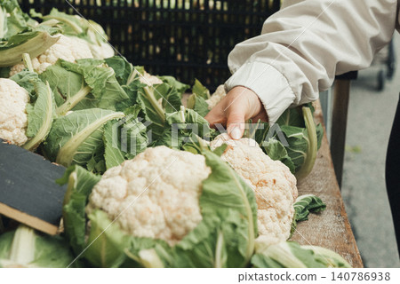 Fresh cauliflower heads rest on a wooden counter Fresh cauliflower heads rest on a wooden counter 140786938