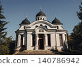 White church with black domes stands under clear blue sky 140786942