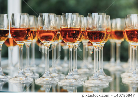 Rows of wine glasses gleam on a polished surface Rows of wine glasses gleam on a polished surface 140786947