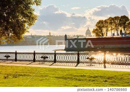 Isaac cathedral, Winter Palace, picturesque metal railings with a double-headed eagle and the crown of the Russian Empire on embankment in St. Petersburg, autumn sunset, incredible sun glare, Russia Isaac cathedral, Winter Palace, picturesque metal railings with a double-headed eagle and the crown of the Russian Empire on embankment in St. Petersburg, autumn sunset, incredible sun glare, Russia 140786980