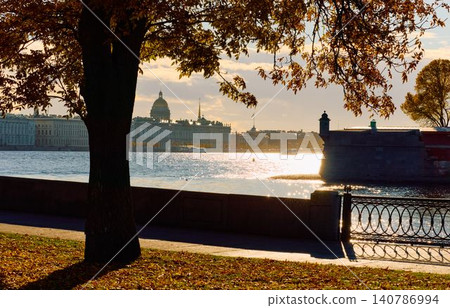 Isaac cathedral, Winter Palace, picturesque metal railings with a double-headed eagle and the crown of the Russian Empire on embankment in St. Petersburg, autumn sunset, incredible sun glare, Russia Isaac cathedral, Winter Palace, picturesque metal railings with a double-headed eagle and the crown of the Russian Empire on embankment in St. Petersburg, autumn sunset, incredible sun glare, Russia 140786994