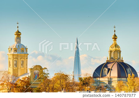 The golden spire of the Peter and Paul Fortress through yellow leaves in Saint-Petersburg - Russia at sunny autumn day, cross with angel on spire, red leaves, sunset, clear sky 140787077
