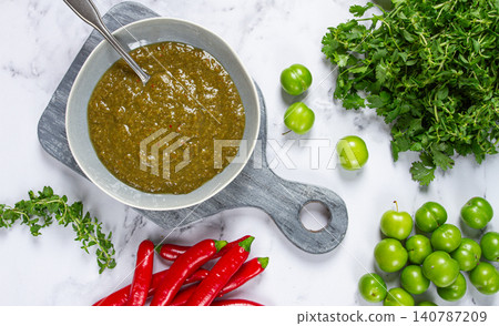 Tkemali sauce, made from green cherry plum, with ingredients on the table, top view, Georgian cuisine, no people, Tkemali sauce, made from green cherry plum, with ingredients on the table, top view, Georgian cuisine, no people, 140787209