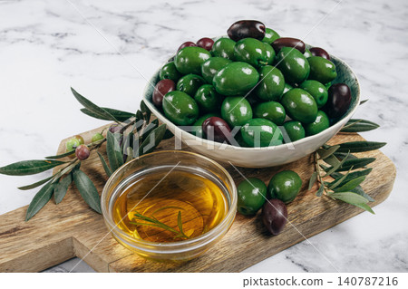 Chalkidiki olives, classic Greek green olives, in a bowl on a cutting board, top view, without people, Chalkidiki olives, classic Greek green olives, in a bowl on a cutting board, top view, without people, 140787216
