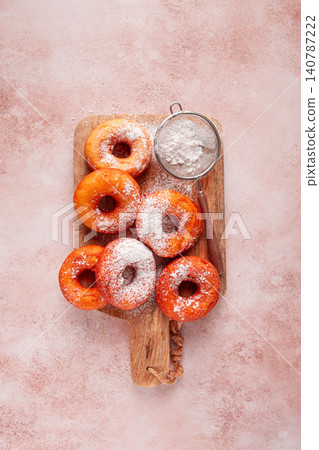Place the baked donuts on a cutting board, sprinkled with powdered sugar, home cooking, no people, Place the baked donuts on a cutting board, sprinkled with powdered sugar, home cooking, no people, 140787222