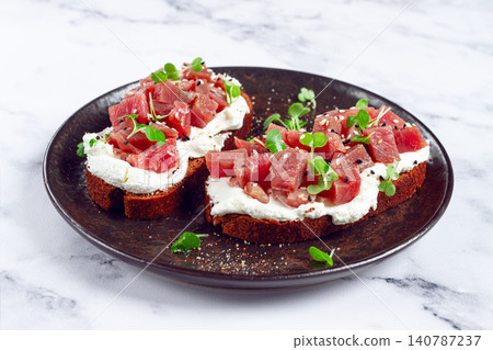 sandwiches, rye bread with cream cheese, sliced tuna fillet with herbs, breakfast on a black plate, homemade, sandwiches, rye bread with cream cheese, sliced tuna fillet with herbs, breakfast on a black plate, homemade, 140787237