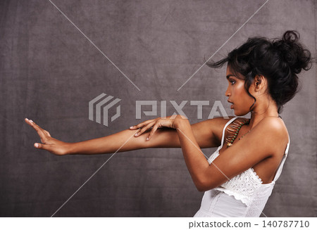 Woman, confident and fashion with jewelry in studio on grey background with touching arm for heritage or culture. Profile, female person and beauty with traditional necklaces, outfit and confidence Woman, confident and fashion with jewelry in studio on grey background with touching arm for heritage or culture. Profile, female person and beauty with traditional necklaces, outfit and confidence 140787710