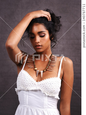 Woman, tradition and necklace with fashion, culture and thinking on a grey background with confidence. Person, model and girl with stylish clothes or casual outfit with symbol or indigenous jewellery Woman, tradition and necklace with fashion, culture and thinking on a grey background with confidence. Person, model and girl with stylish clothes or casual outfit with symbol or indigenous jewellery 140787711