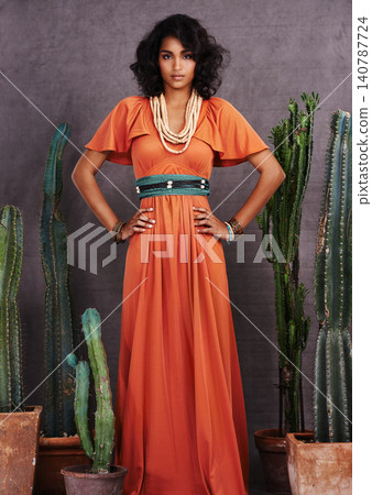 Indian woman, fashion and confident with jewelry in studio on grey background with cacti props and dress. Portrait, female person and outfit with traditional necklace, trendy and creative look. Indian woman, fashion and confident with jewelry in studio on grey background with cacti props and dress. Portrait, female person and outfit with traditional necklace, trendy and creative look. 140787724