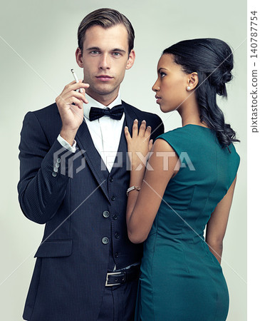 Fashion, smoking and portrait for couple, vintage and style for cosplay and trend for classic and classy. Diverse people and gentleman with girlfriend and cigarette for confident, rich and luxury Fashion, smoking and portrait for couple, vintage and style for cosplay and trend for classic and classy. Diverse people and gentleman with girlfriend and cigarette for confident, rich and luxury 140787754