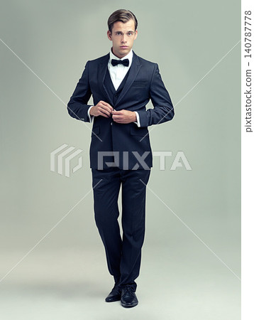 Gentleman, studio and portrait with rich, vintage and class for retro style and fashion. Man, spy or agent with tuxedo, suit and luxury with confidence for black tie isolated on white background 140787778