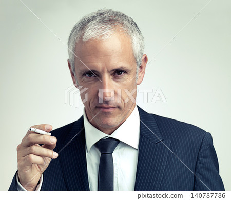 Portrait, suit and mature man smoking cigarette with salesman in studio isolated on a gray background. Face, fashion and serious businessman with tobacco, ceo or manager in vintage clothes in Canada Portrait, suit and mature man smoking cigarette with salesman in studio isolated on a gray background. Face, fashion and serious businessman with tobacco, ceo or manager in vintage clothes in Canada 140787786