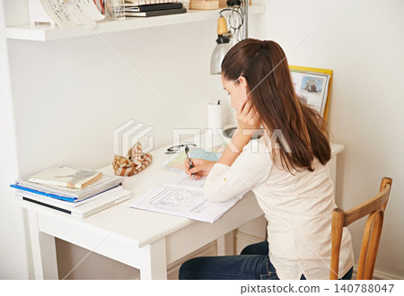 Teen, girl and book for studying in home, student and homework for assignment or project. Female person, learner and schoolwork on weekend, education and knowledge or information by learning at desk 140788047