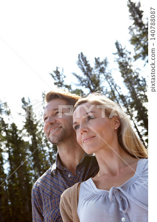 Couple, nature and view outdoor with travel for vacation, man and woman with fresh air for bonding in environment. Love, support and trust with low angle, happy and calm with peace in forest together 140788087