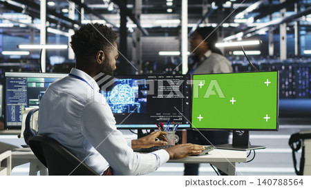 System administrator uses node tree AI software on a green screen computer for data center analysis. 140788564