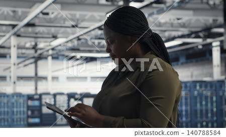 IT specialist uses tablet in a data center to upgrade server hardware and improve workload capacity. IT specialist uses tablet in a data center to upgrade server hardware and improve workload capacity. 140788584