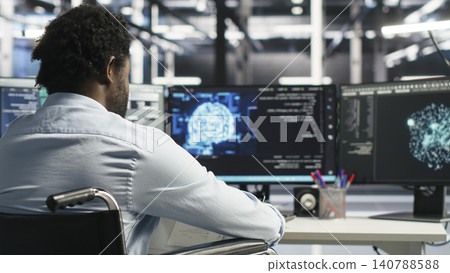 Worker using a wheelchair operates AI node tree software in a data center to monitor performance data. 140788588