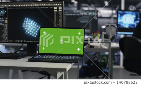 Software developer uses a green screen laptop to manage AI systems, machine learning workflows and server performance. Software developer uses a green screen laptop to manage AI systems, machine learning workflows and server performance. 140788622