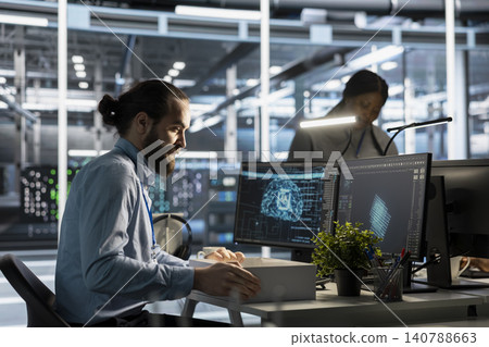 Upset data center engineer packs desk belongings after AI automation replaces part of an infrastructure operations role. Upset data center engineer packs desk belongings after AI automation replaces part of an infrastructure operations role. 140788663