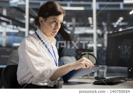 System operator reviews performance analytics on a desktop computer in a data center to optimize storage systems and resource use. System operator reviews performance analytics on a desktop computer in a data center to optimize storage systems and resource use. 140788684