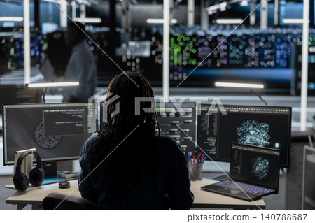 Software developer uses a desktop computer in a data center to support automation monitoring and reliable server workflows. 140788687