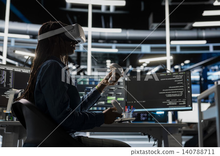 Computer scientist uses a VR headset in a data center to manage AI systems, train neural networks, and configure hardware. 140788711