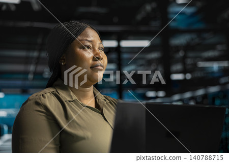 System administrator uses a laptop computer in a data center to monitor equipment, manage workflows, and support reliable infrastructure. System administrator uses a laptop computer in a data center to monitor equipment, manage workflows, and support reliable infrastructure. 140788715