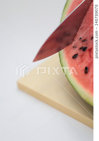 Cut the watermelon with a kitchen knife Cut the watermelon with a kitchen knife 140789078