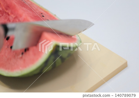 Cut the watermelon with a kitchen knife Cut the watermelon with a kitchen knife 140789079
