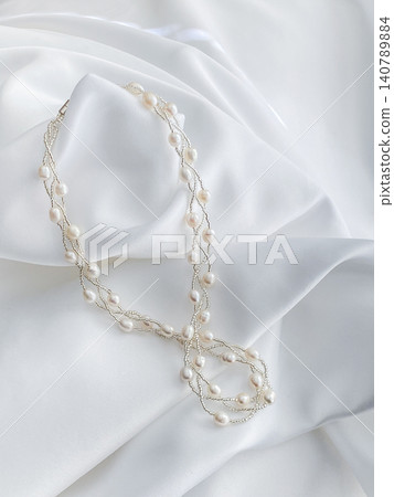 An image of a pearl necklace placed on a white cloth. An image of a pearl necklace placed on a white cloth. 140789884