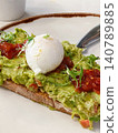 Avocado toast topped with a poached egg 140789885