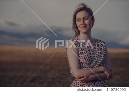 Portrait of a calm smiling young woman in a field Portrait of a calm smiling young woman in a field 140789993