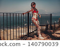 Beautiful woman in swimsuit stands on the beach on lake background 140790039