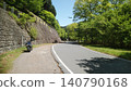 A motorcycle tour where you stop your bike on a mountain road surrounded by fresh greenery and enjoy the scenery. 140790168