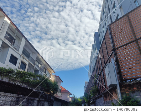 Sky cloud building street urban upward view of narrow lane under textured sky Sky cloud building street urban upward view of narrow lane under textured sky 140790392
